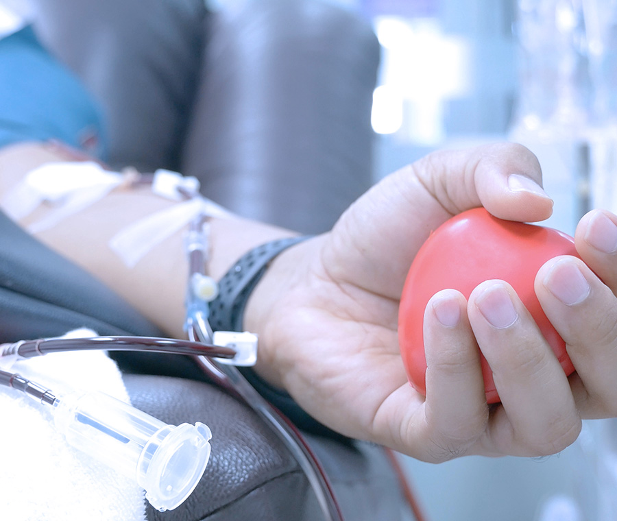 Hand squeezing rubber ball while giving blood