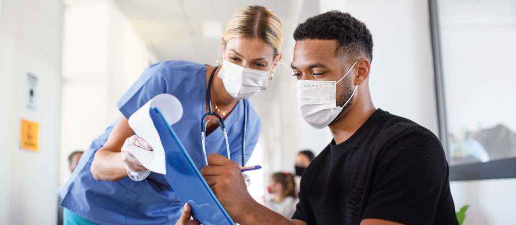 Patient with mask on filling out paperwork